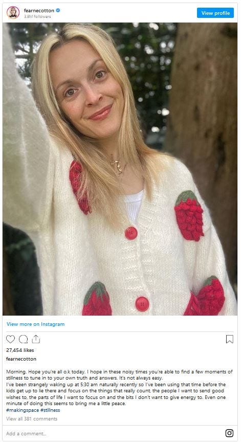 Instagram snapshot of Fearne Cotton with one arm up, leaning to the left, wearing a white sweater with strawberries